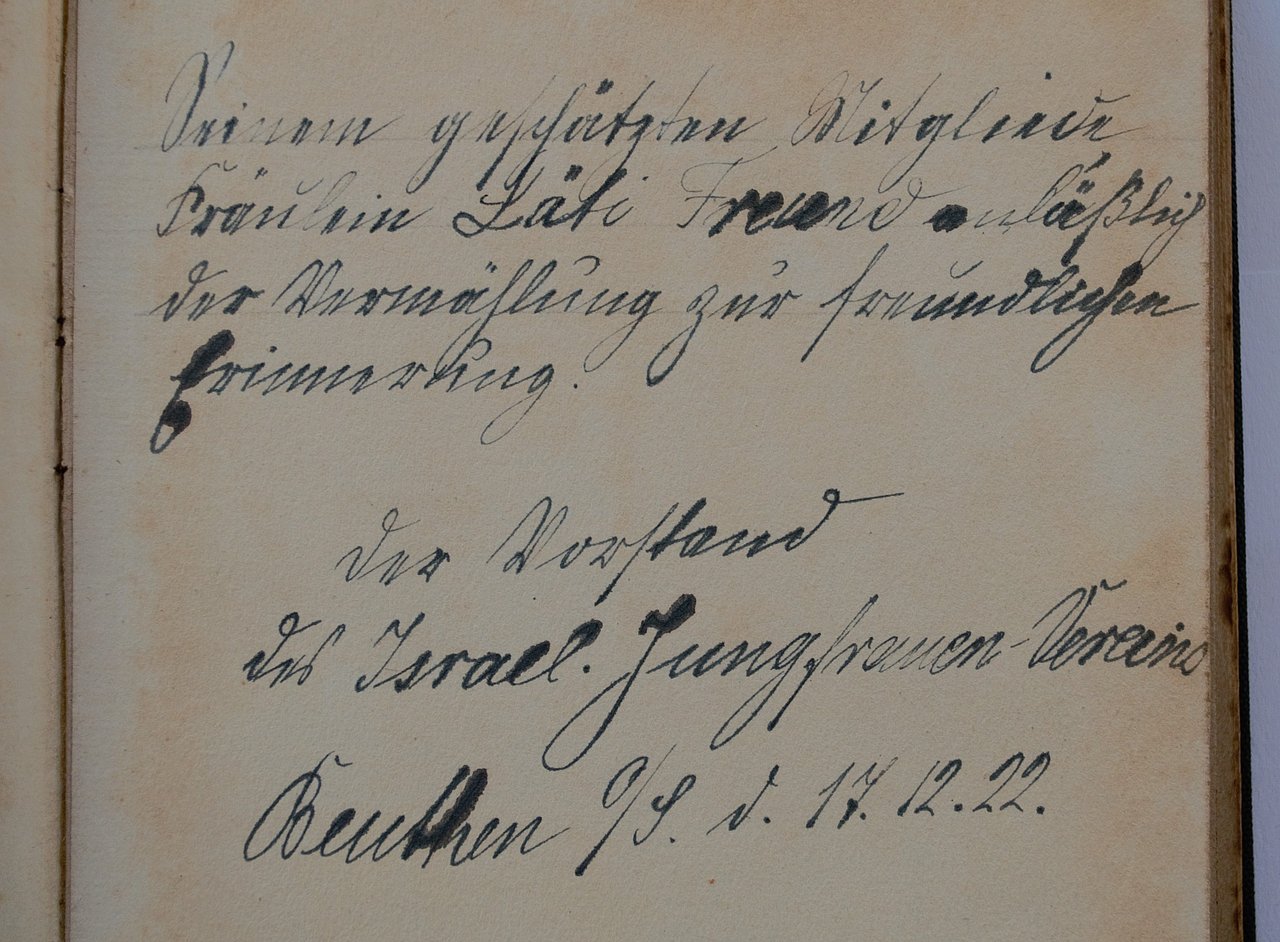 [Translate to English:] Handgeschriebener Vorsatz im Buch auf Sütterlin: " Seinem geschätzten Mitgliede Fräulein Läti [?] Freund anlässlig [anlässlich] der vermählung zur freundlichen Erinnerung. Der Vorstand des Israel. Jungfrauen-Vereins Beuthen O/S. d. 17.12.22"