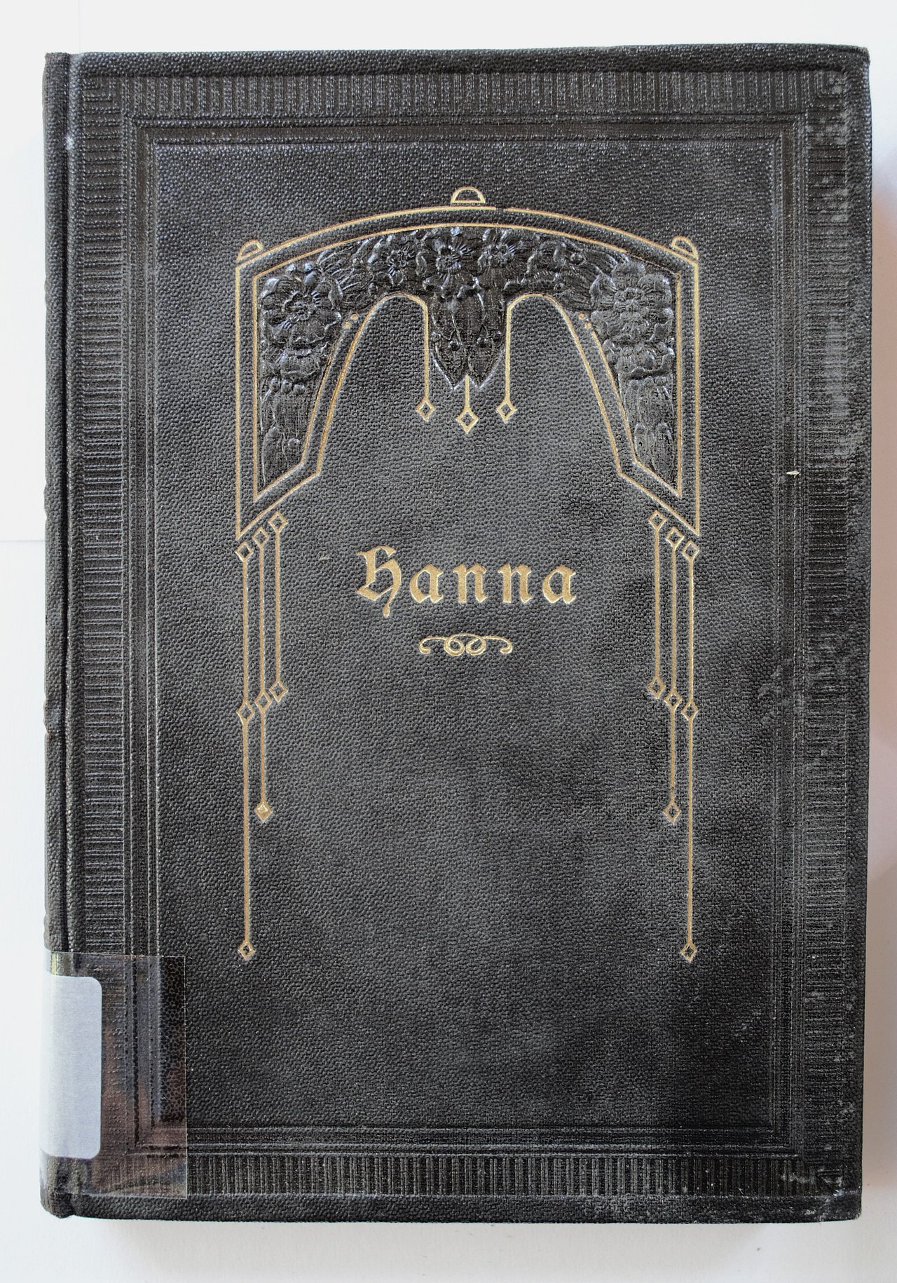 [Translate to English:] Cover des Buches "Hanna". Es ist komplett in schwarz gestaltet, lediglich der Titel und ein ornamentaler Rahmen um jenen tragen die Farbe gold. Der Einband sieht künstlerisch aus.