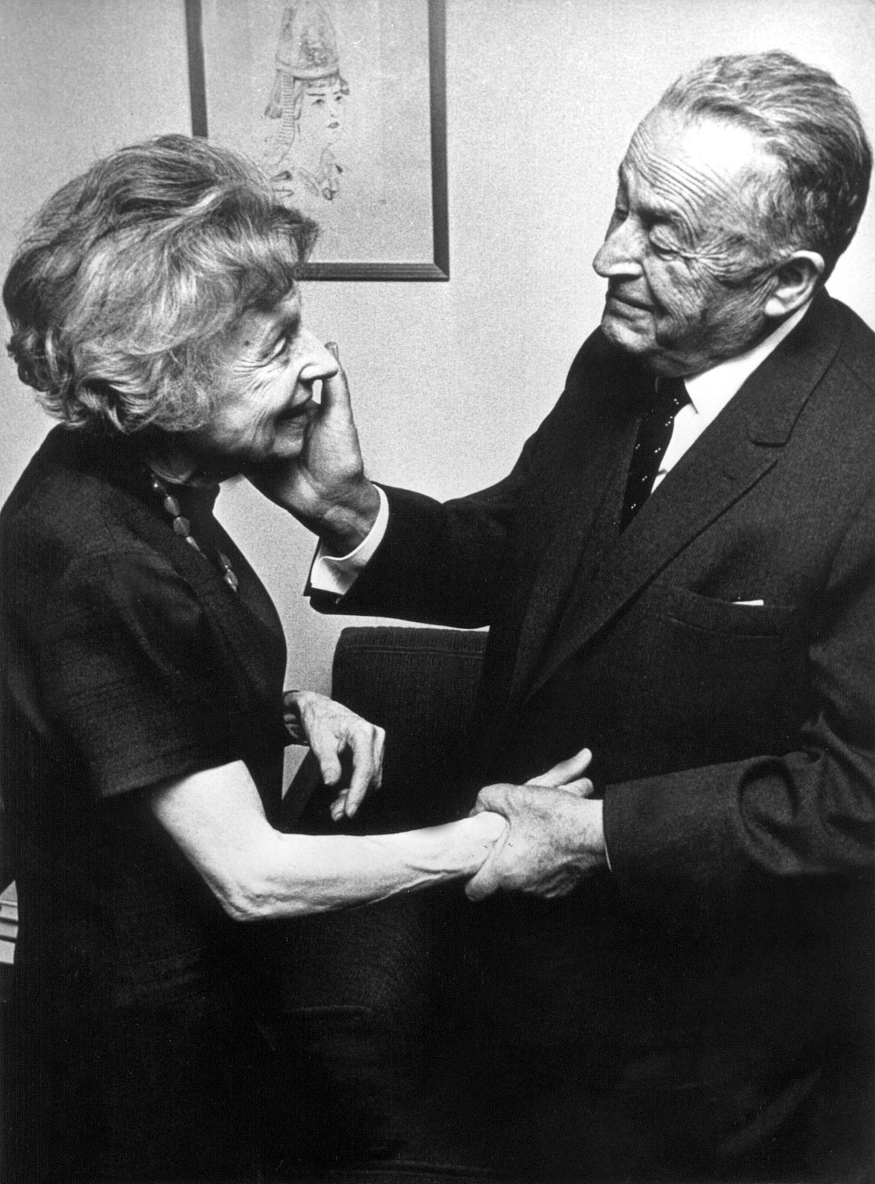Schwarz-Weiß-Fotografie von einem älteren Mann und einer älteren Feau, die sich die Hand reichen