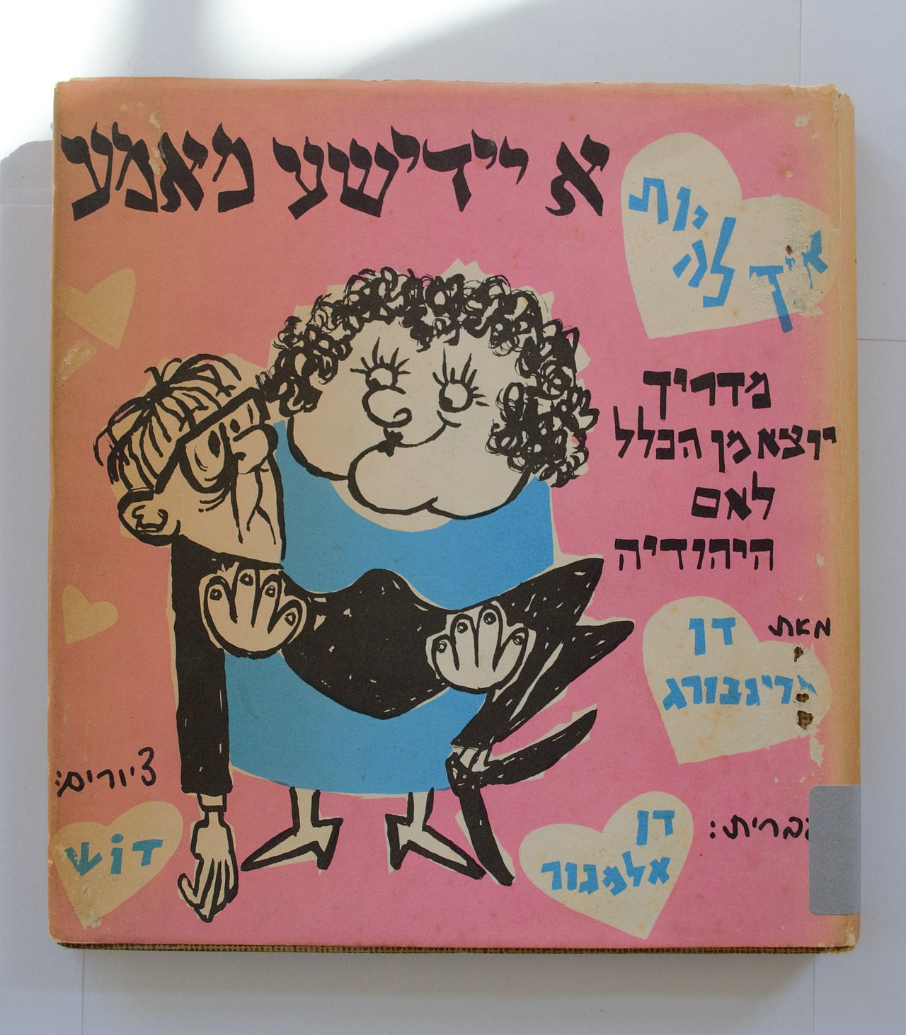 [Translate to English:] Cover des Buches zeigt Illustration einer Frau, die einen Mann in den Armen trägt. Der Hintergrund ist rosa, es sind Abnutzungserscheinungen erkennbar.