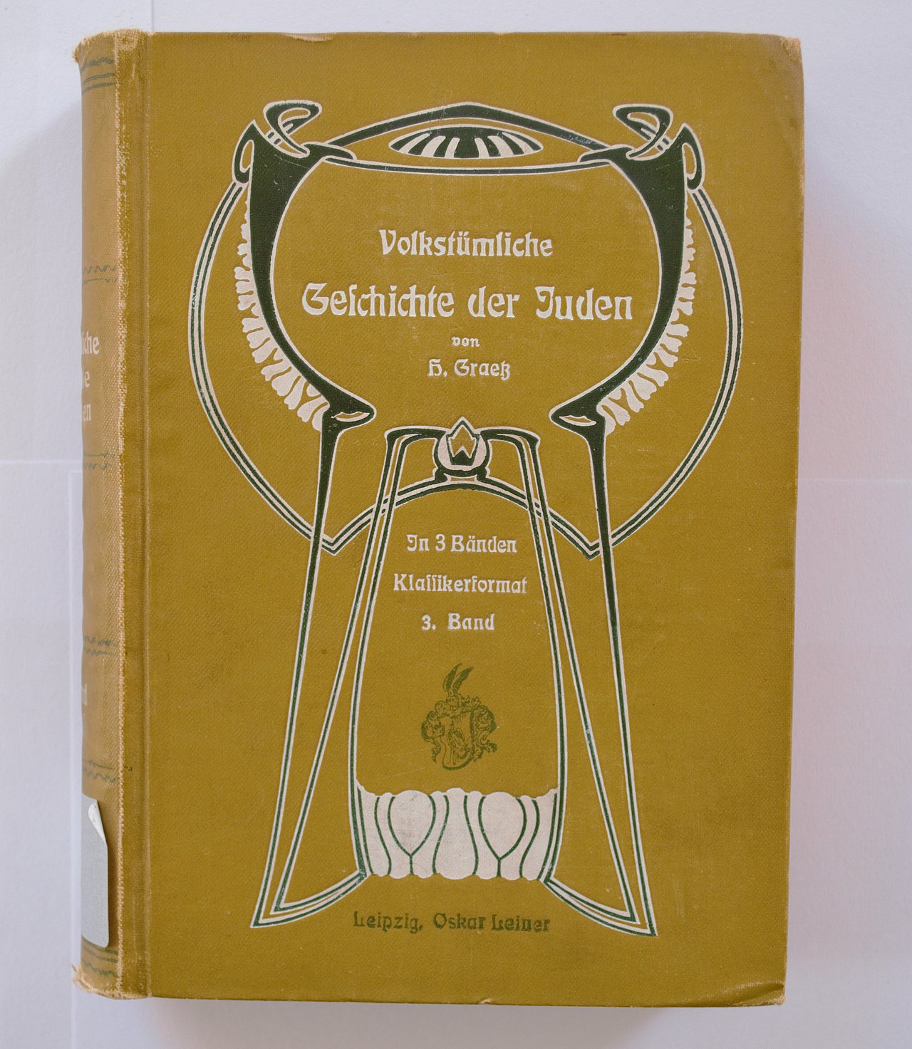 [Translate to English:] Cover des Buches in senfgelber Farbe und einer illustration im Stil des Art Déco.