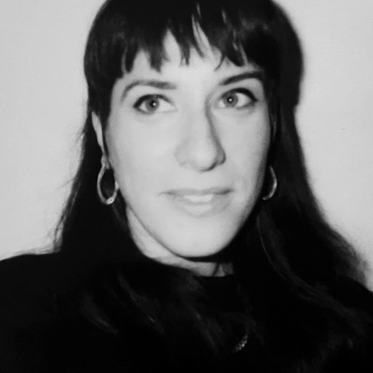Schwarz-weiß Portrait von Isabel Jacobs, einer Frau mit schwarzen Haaren, an der Kamera vorbei blickend